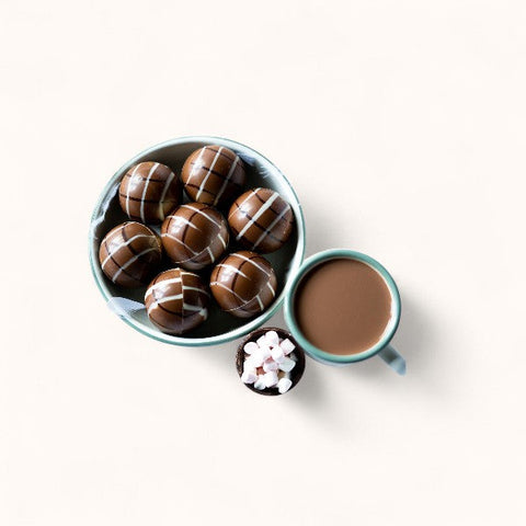 Chocolat chaud gourmande et cuillères en chocolat à faire fondre pour une boisson onctueuse et réconfortante aux saveurs chocolatées.